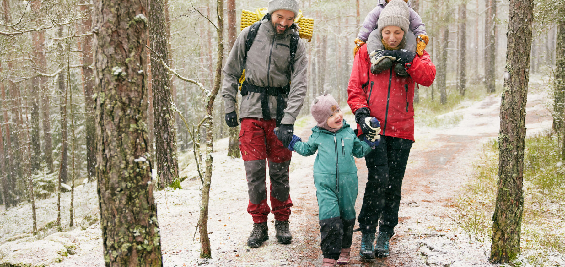 Familie på tur ute i snøvær